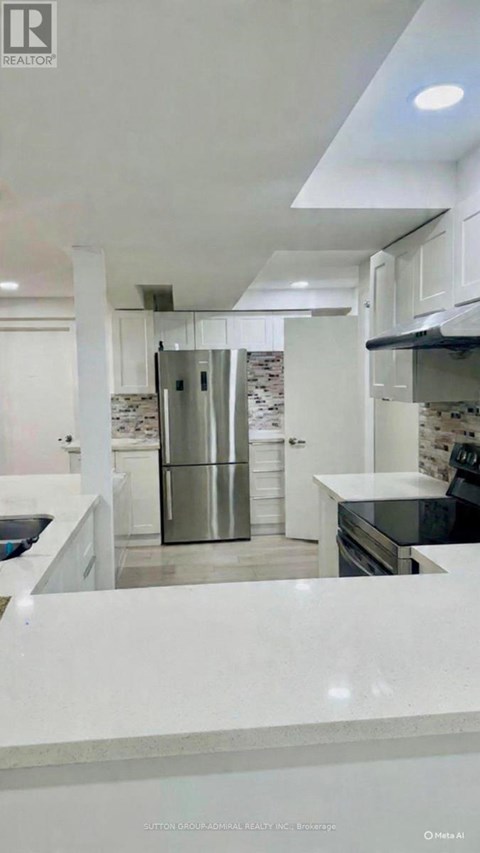 A modern kitchen with white cabinets and a marble countertop.