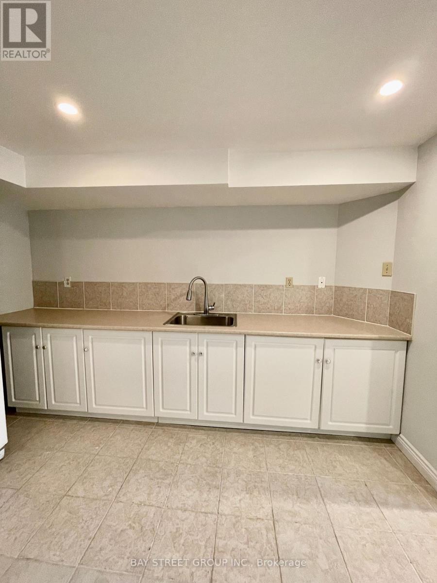 A kitchen with white cabinets and a beige backsplash.
