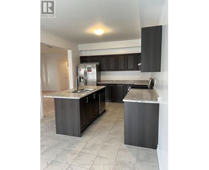 A kitchen with black cabinets and a marble countertop.