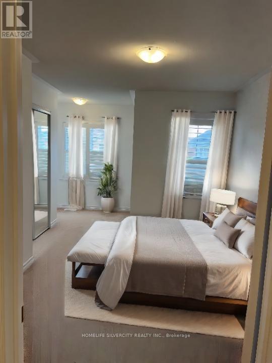 A bedroom with a large bed and a window with curtains.