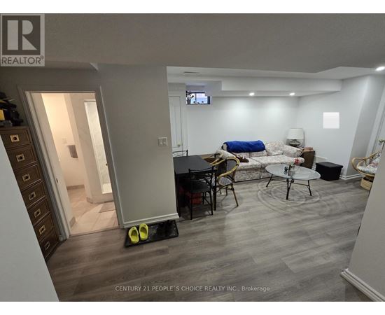 A living room with a TV on the wall and a couch.