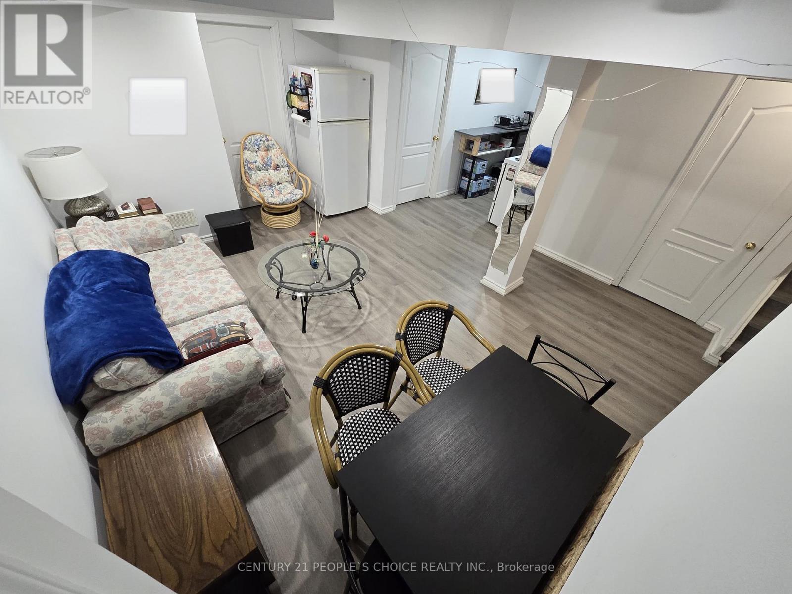 A small, messy bedroom with a table and chairs.