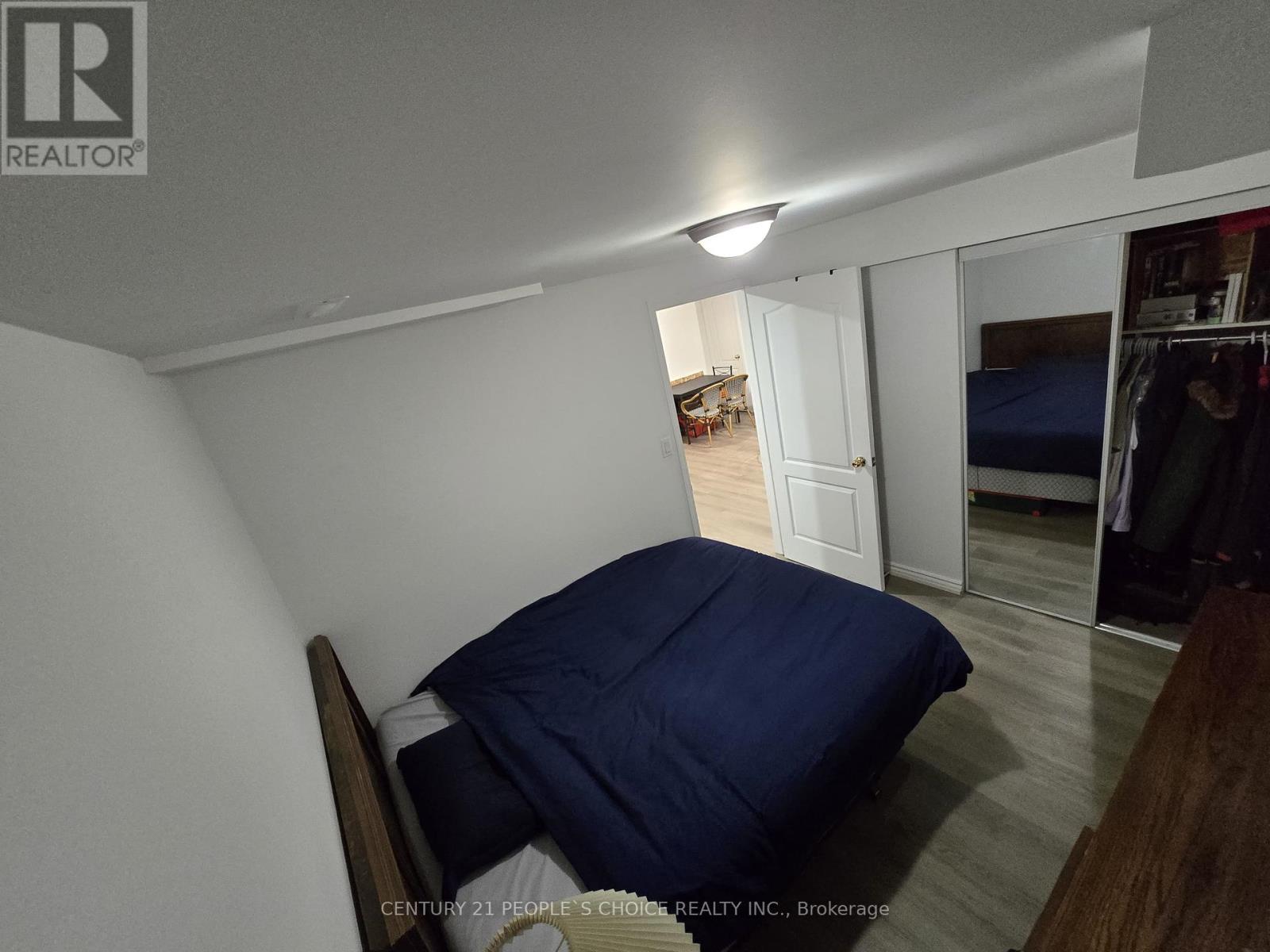 A bedroom with a bed and a blue pillow is shown.