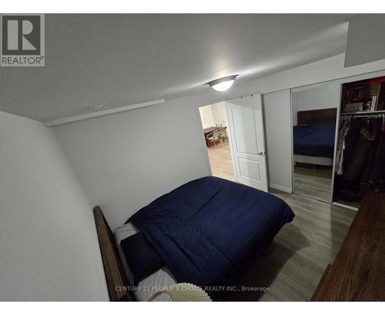 A bedroom with a bed and a blue pillow is shown.