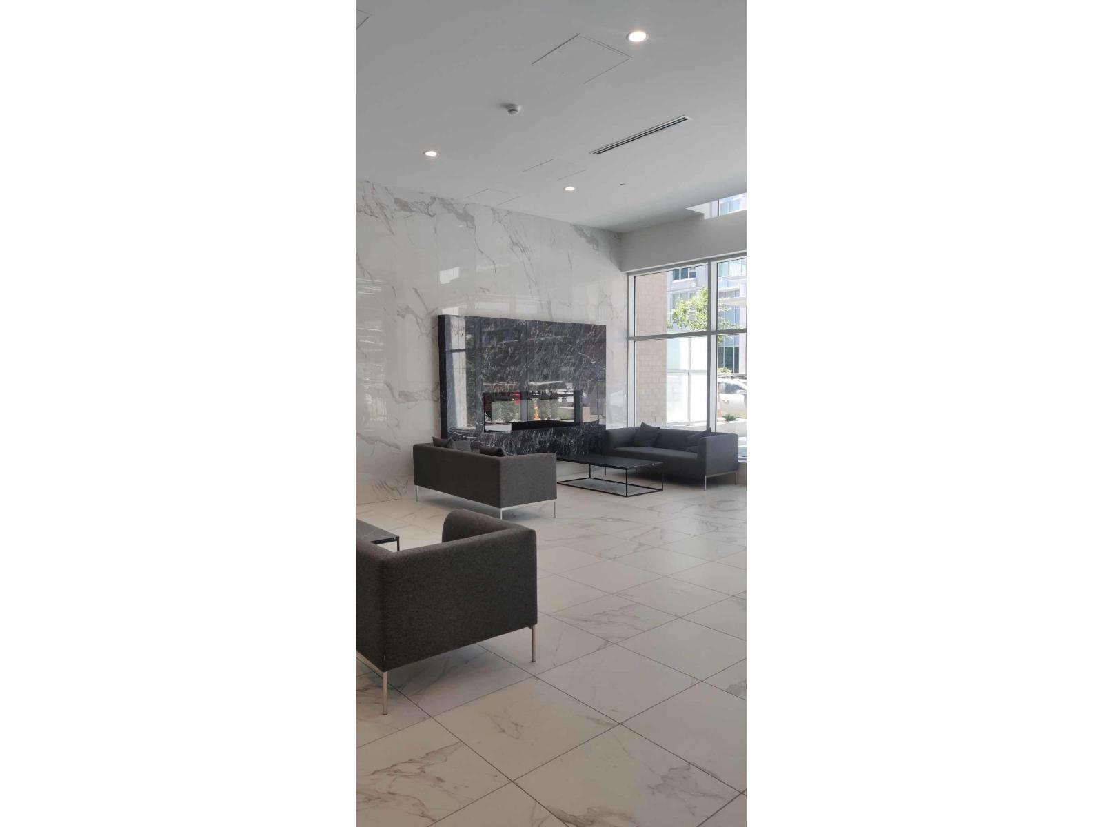 A modern living room with a fireplace and a grey sofa.