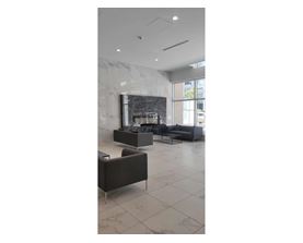A modern living room with a fireplace and a grey sofa.