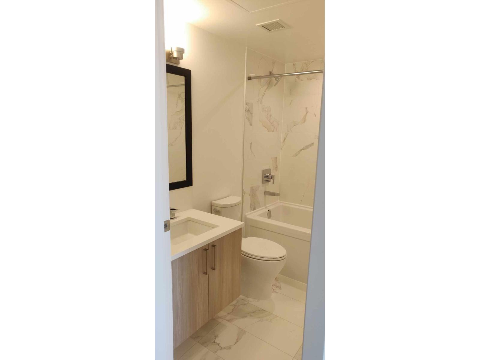 A bathroom with a toilet, sink, and shower.