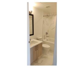 A bathroom with a toilet, sink, and shower.