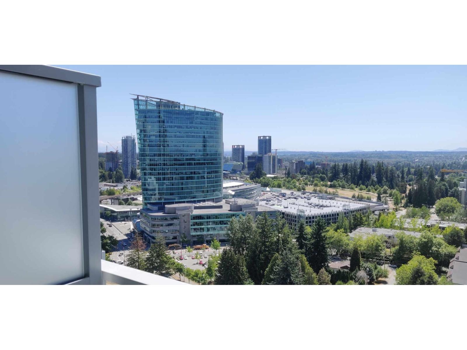A modern glass building stands out in a cityscape.
