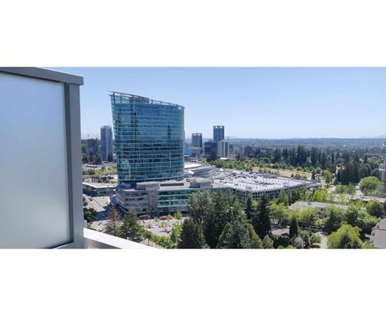 A modern glass building stands out in a cityscape.