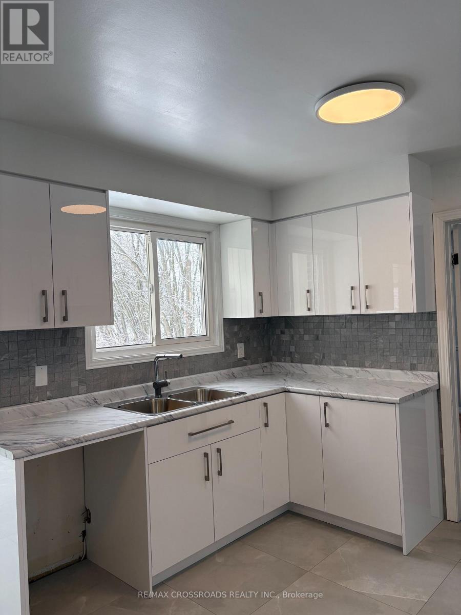 A kitchen with white cabinets and a marble countertop.