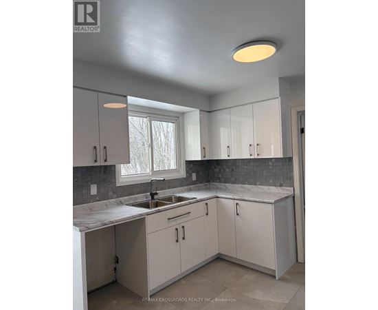 A kitchen with white cabinets and a marble countertop.