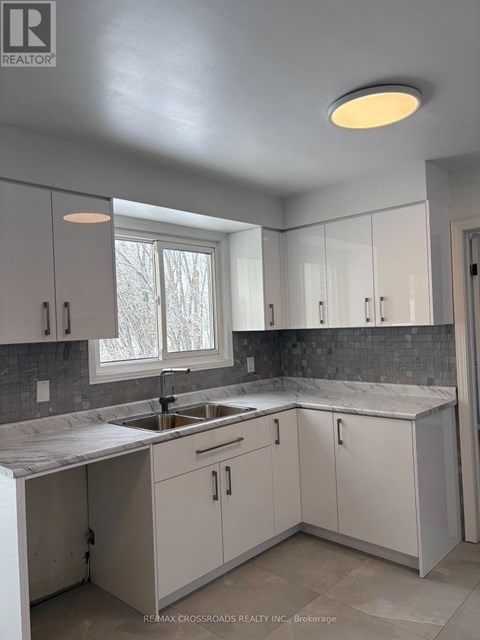 A kitchen with white cabinets and a marble countertop.