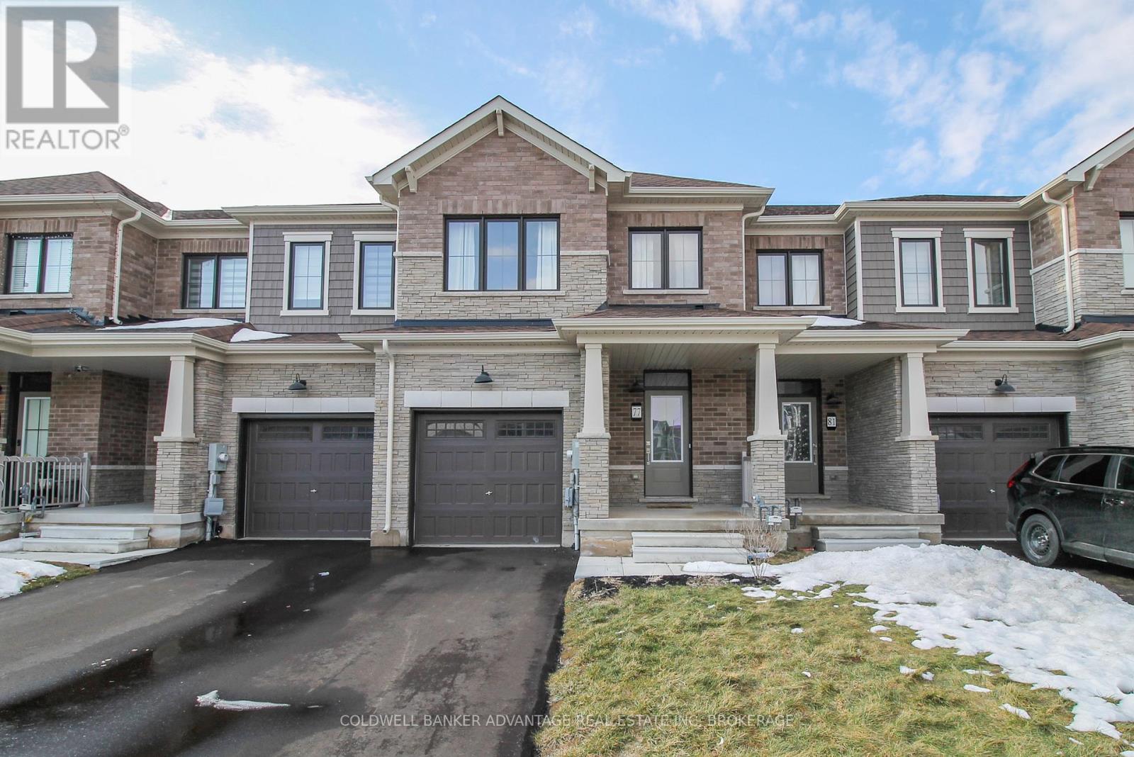 A large, multi-level house with a driveway in front.