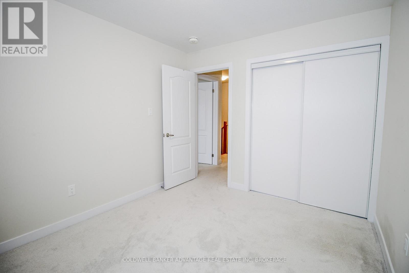 A white bedroom with a door and a window.