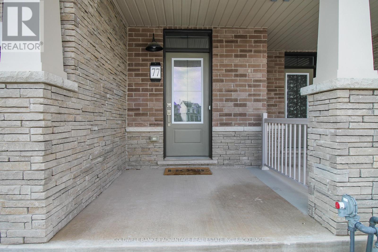 A house entrance with a grey door and a sign that says "REALTOR".