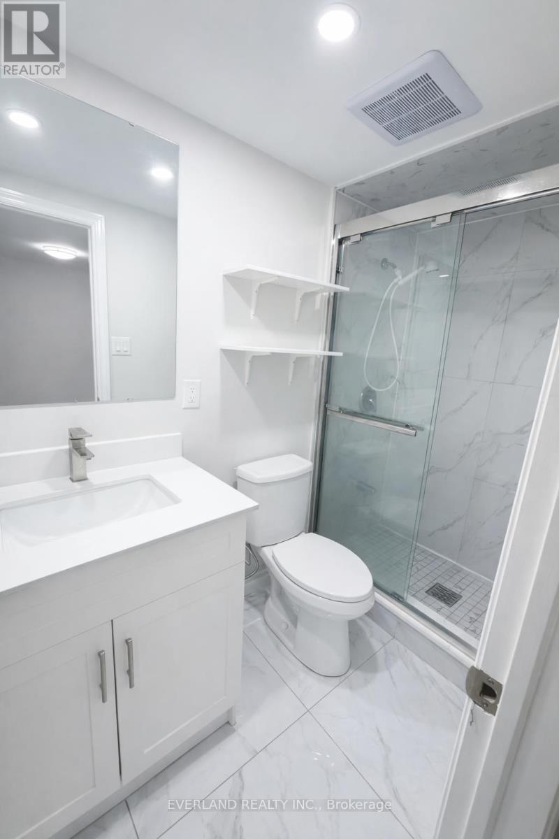 A white bathroom with a glass shower door.
