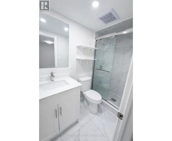 A white bathroom with a glass shower door.