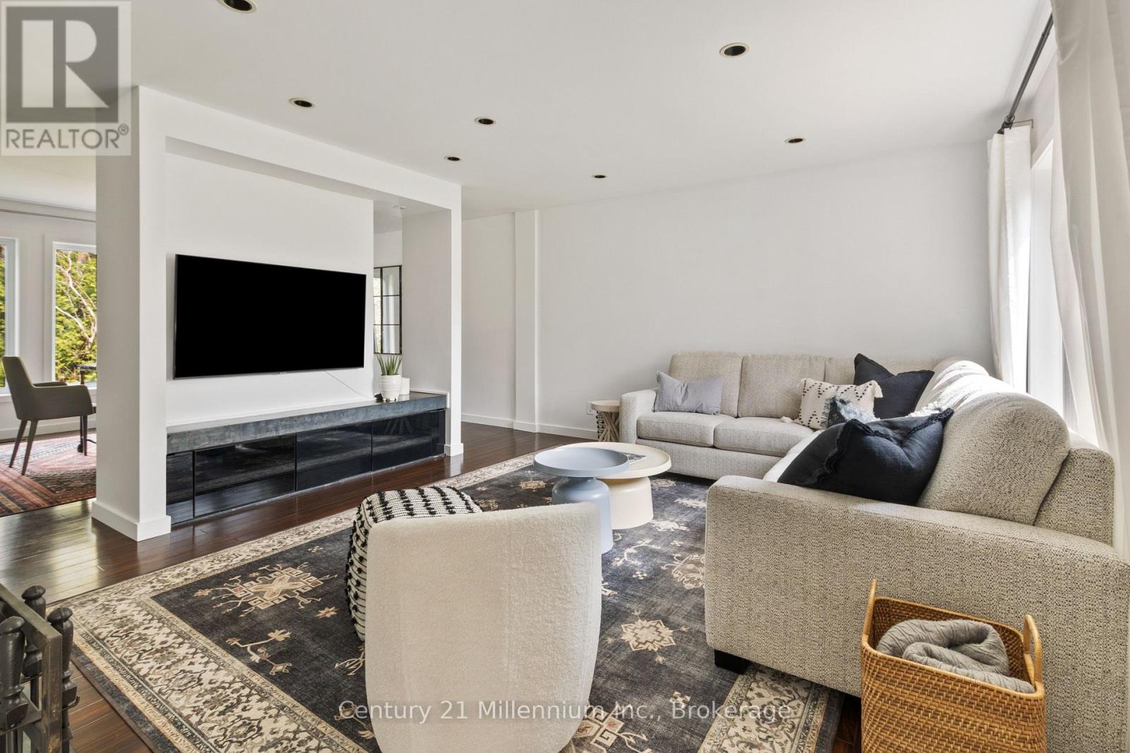A living room with a grey couch and a black and white rug.
