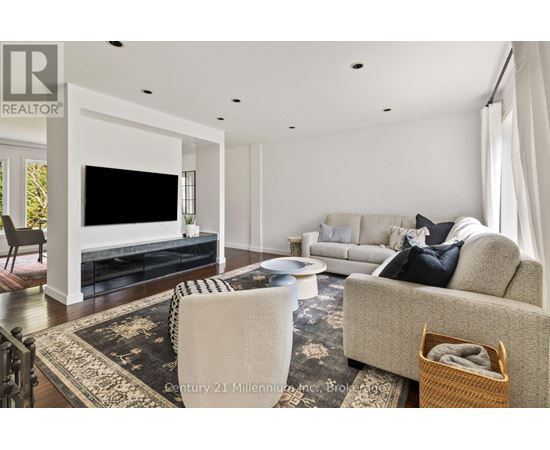 A living room with a grey couch and a black and white rug.