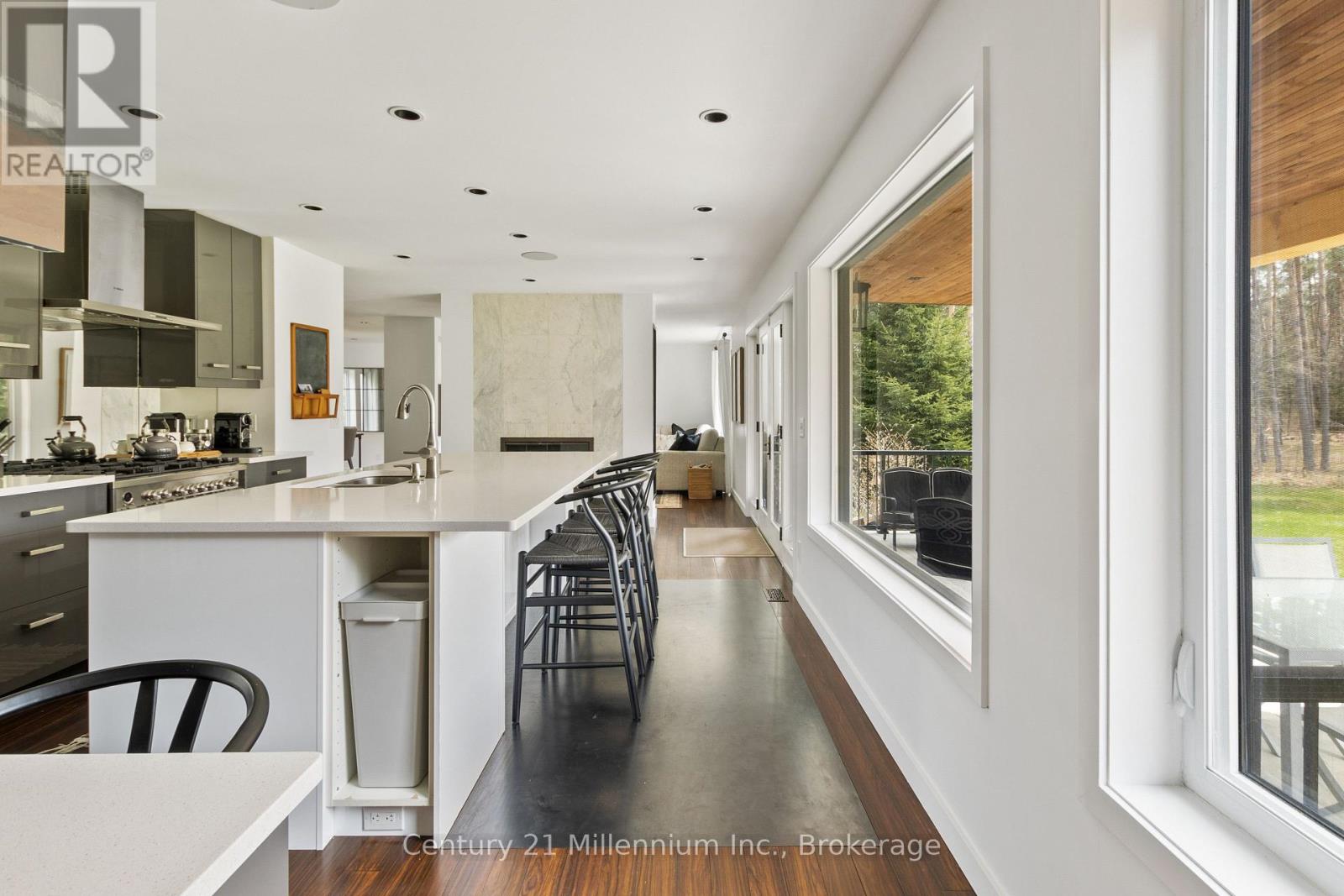 A modern kitchen with a long counter and a view of the backyard.