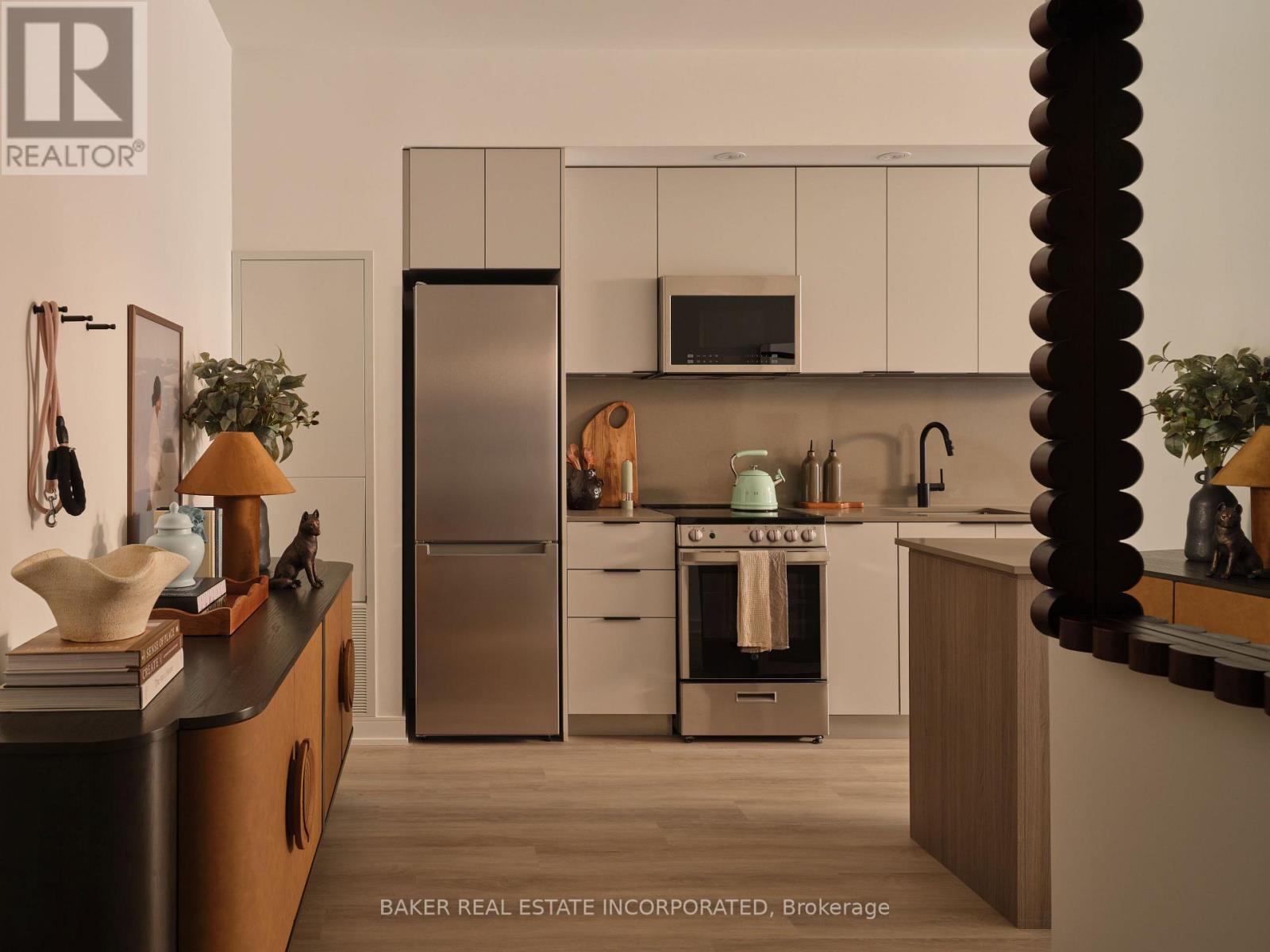 A modern kitchen with a refrigerator, oven, and microwave.