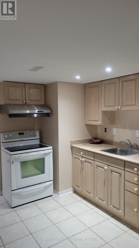 A white stove and oven in a kitchen with beige cabinets.