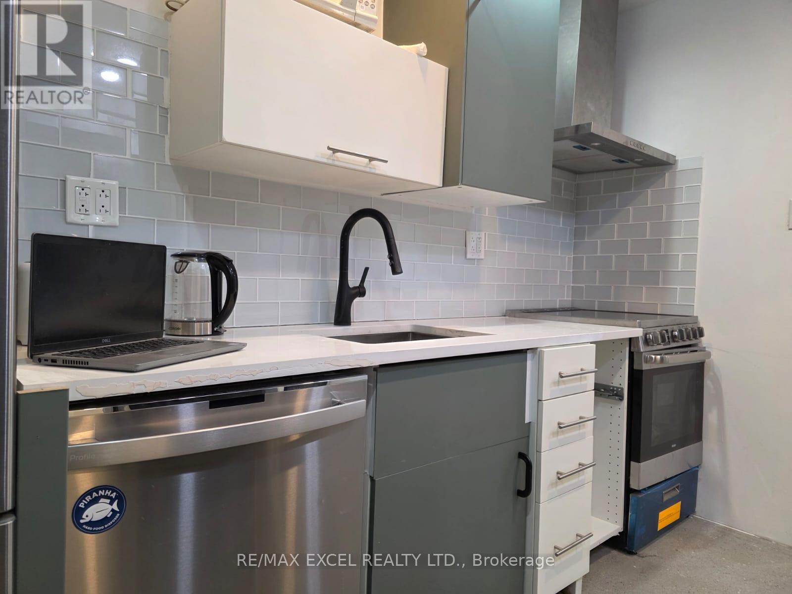 A modern kitchen with a laptop on the counter.