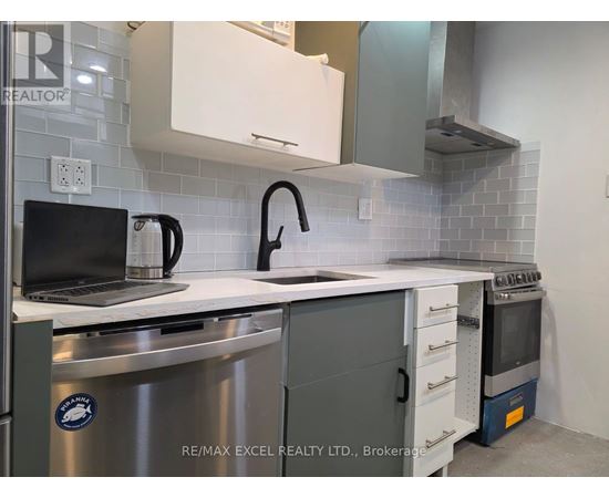 A modern kitchen with a laptop on the counter.