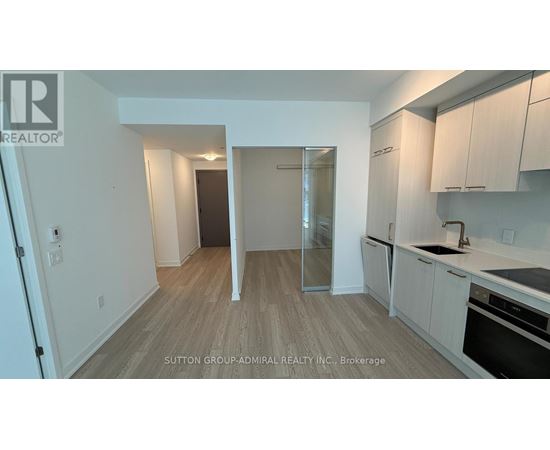 A kitchen with white cabinets and a wooden floor.