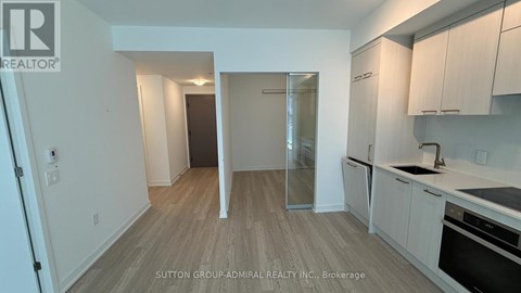 A kitchen with white cabinets and a wooden floor.