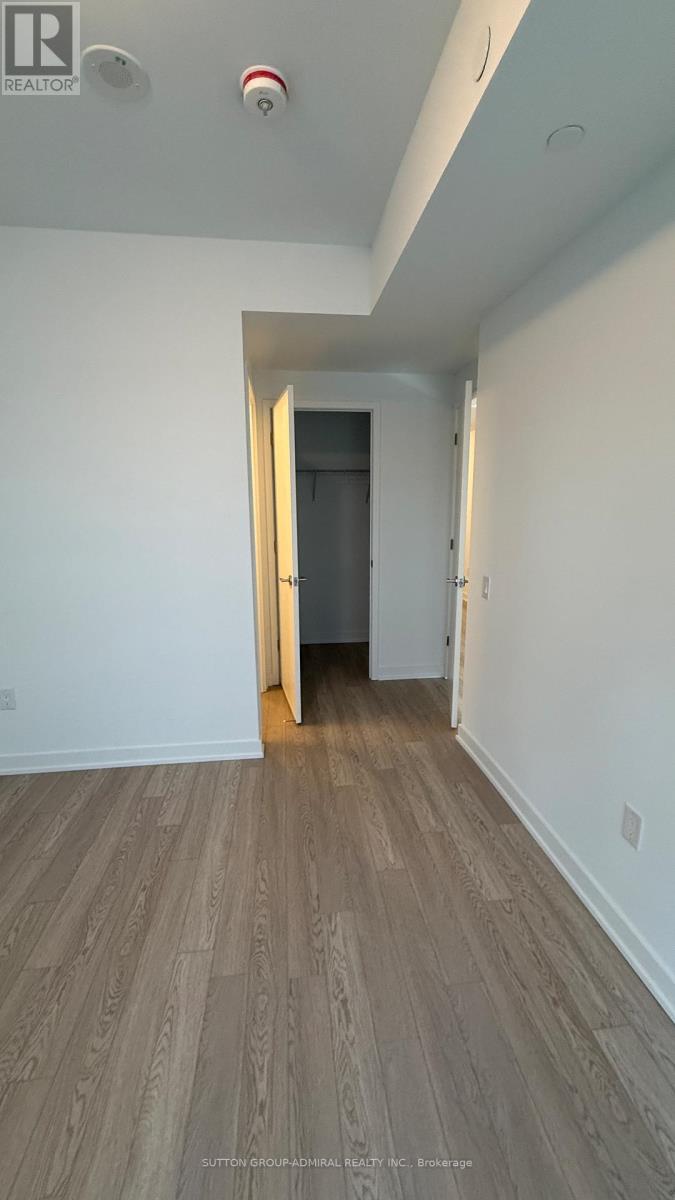 A hallway with a wooden floor and white walls.
