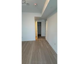 A hallway with a wooden floor and white walls.
