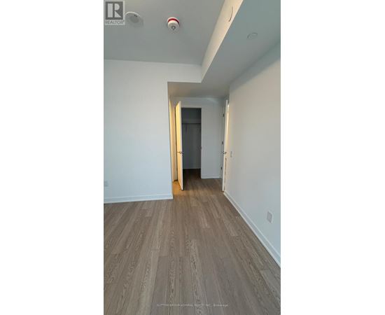 A hallway with a wooden floor and white walls.