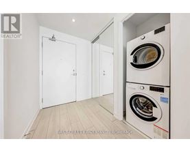 A white washing machine is in a small laundry room.