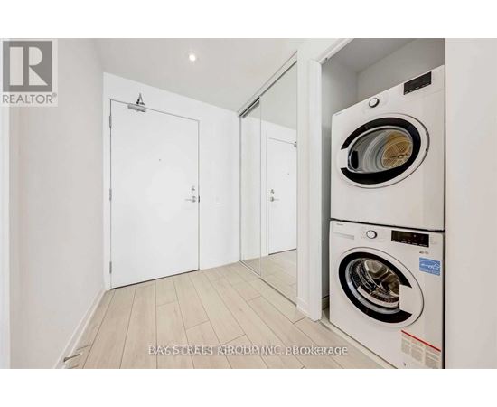 A white washing machine is in a small laundry room.