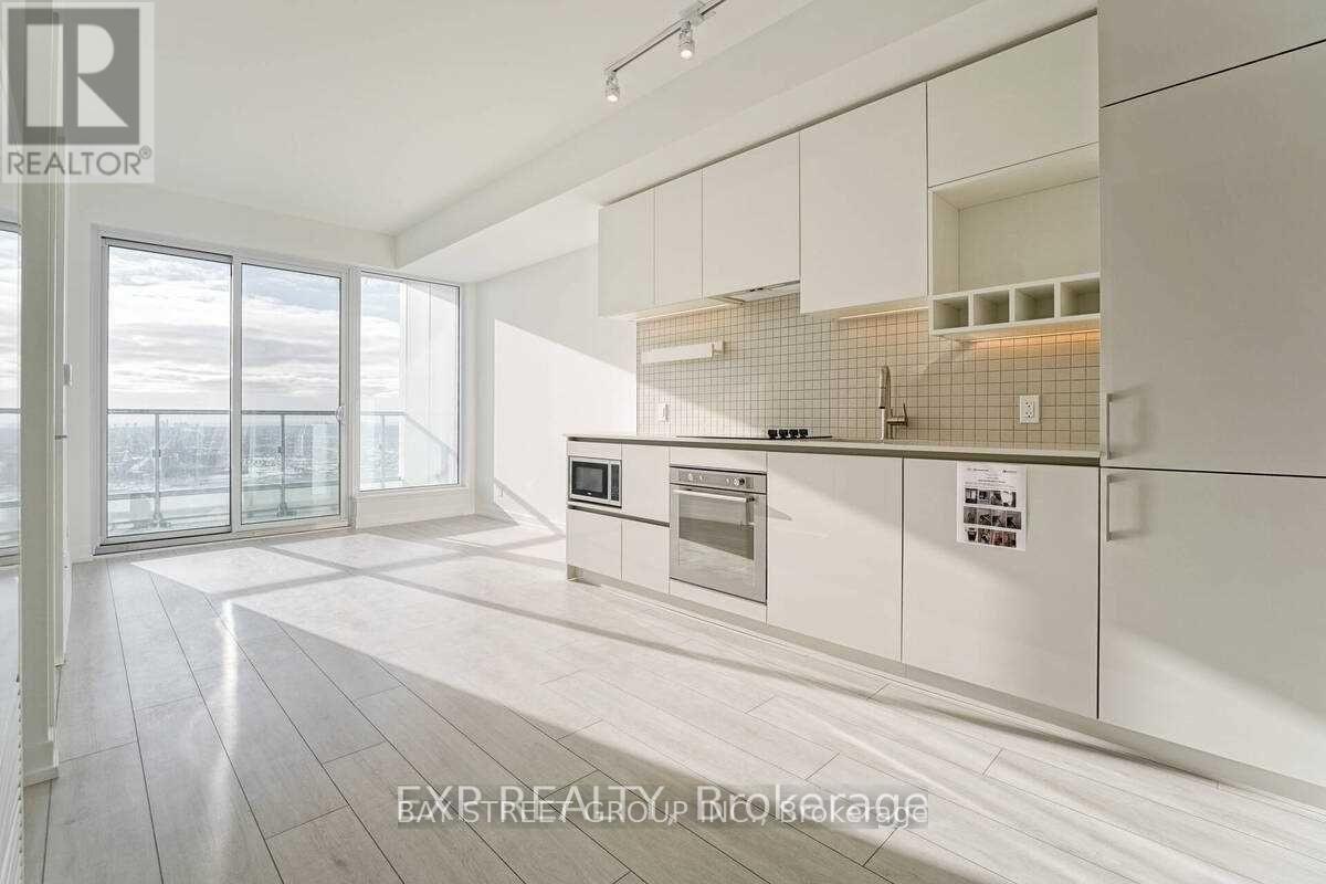 A modern kitchen with white cabinets and a tiled backsplash.
