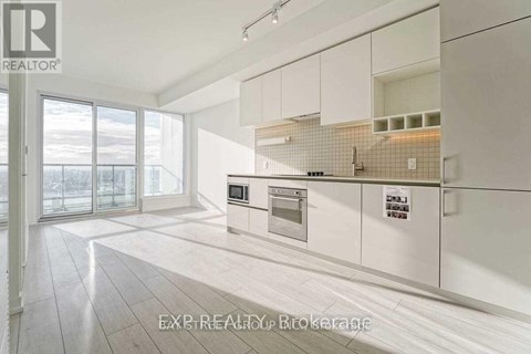A modern kitchen with white cabinets and a tiled backsplash.