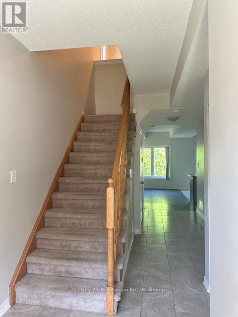 A staircase with a light brown carpet and wooden balusters.