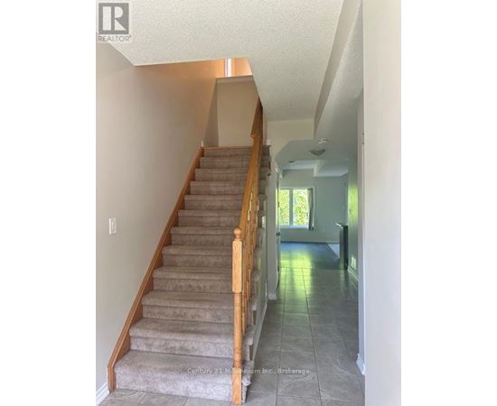 A staircase with a light brown carpet and wooden balusters.