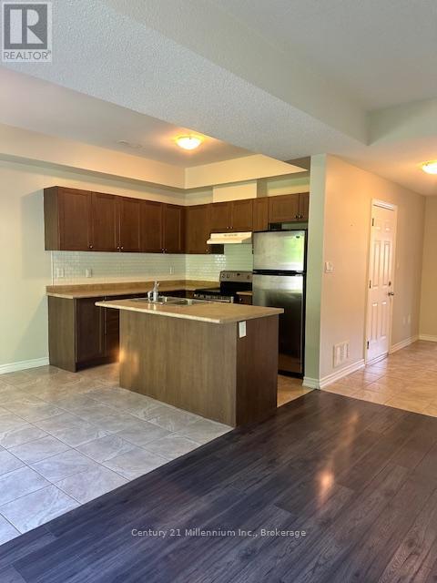A kitchen with wooden cabinets and a black refrigerator.