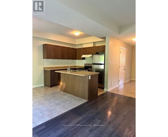 A kitchen with wooden cabinets and a black refrigerator.