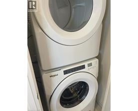 A white Whirlpool washing machine and dryer stacked on top of each other.