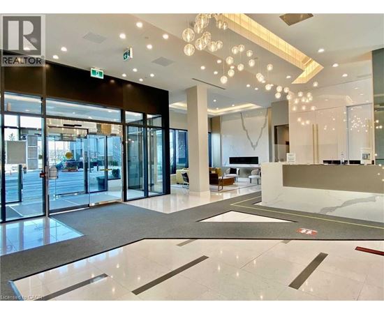 A spacious lobby with a reception desk and a glass door entrance.