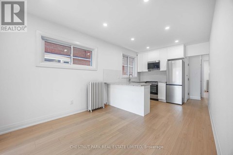A spacious kitchen with white cabinets and stainless steel appliances.