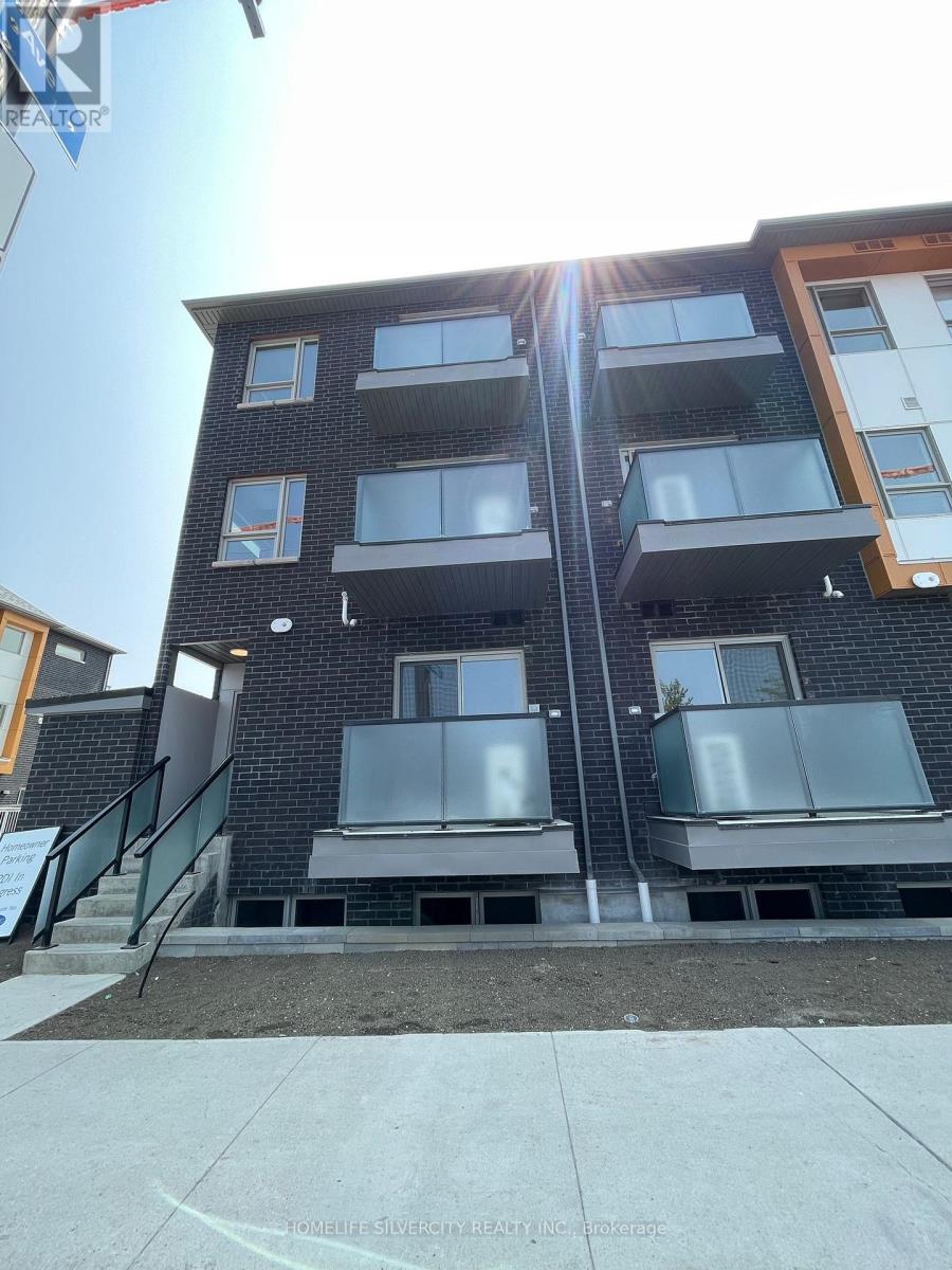 A modern apartment building with black and grey exterior and balconies.