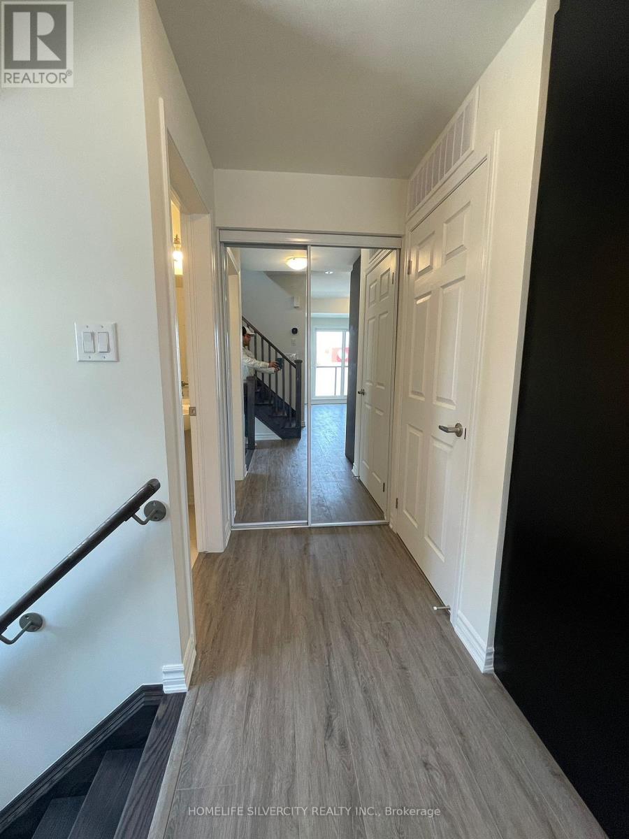 A hallway with a wooden floor and white walls.
