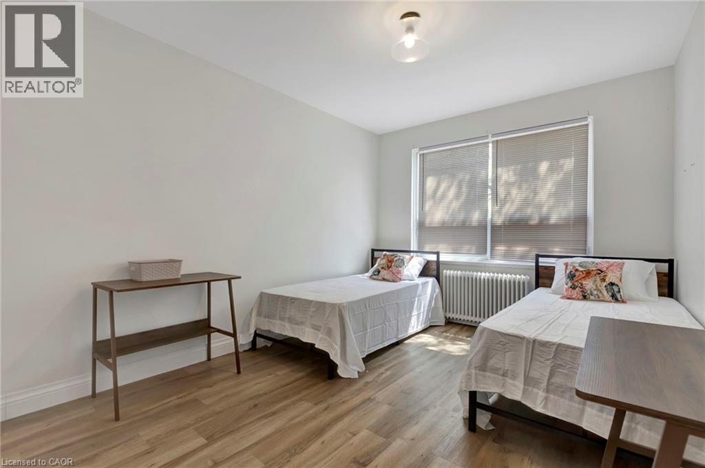 A bedroom with two beds and a desk.