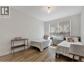 A bedroom with two beds and a desk.