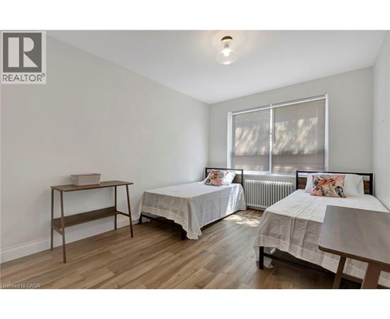 A bedroom with two beds and a desk.